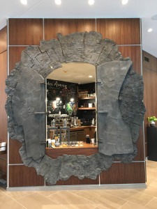 Slab wall sculpture and coffee portal. 111 individually sculpted and cast aluminum tiles make up the surface of this work.